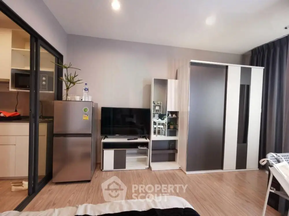Modern studio apartment with sleek furniture and open kitchen layout.