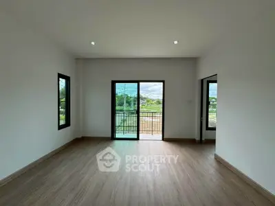 Spacious empty room with large windows and balcony view, perfect for customization.
