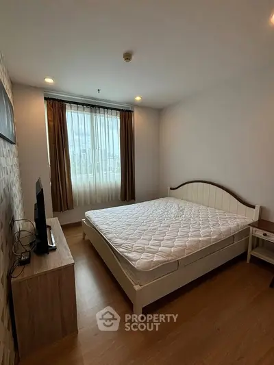 Cozy bedroom with natural light, featuring a comfortable bed and modern decor, perfect for relaxation.