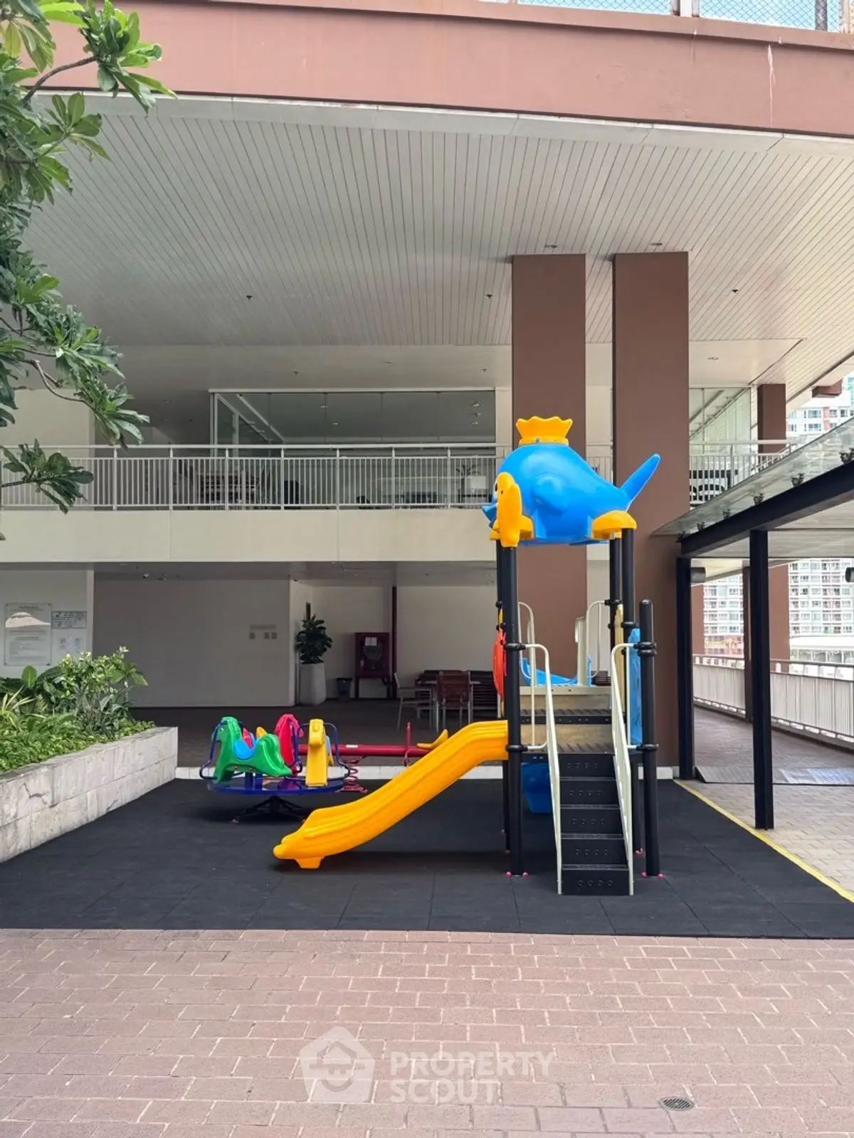 Modern residential building with colorful children's playground area.
