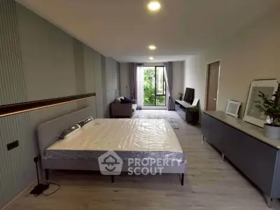 Spacious modern bedroom with large window and stylish decor