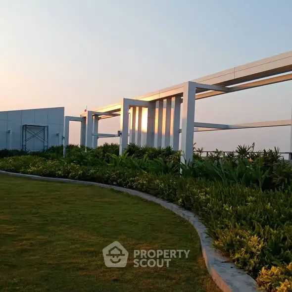 Stunning rooftop garden with modern architectural design and lush greenery at sunset.