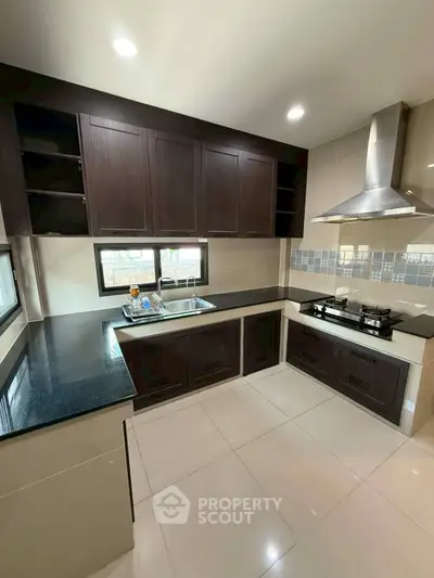Modern kitchen with sleek cabinetry and gas stove in a contemporary home.