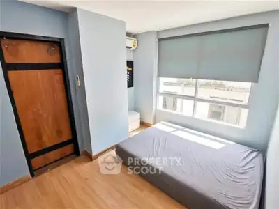 Bright and cozy bedroom with large window and minimalist design, perfect for modern living.