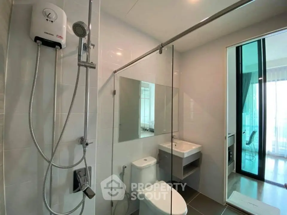 Modern bathroom with glass shower and sleek fixtures in a contemporary apartment.
