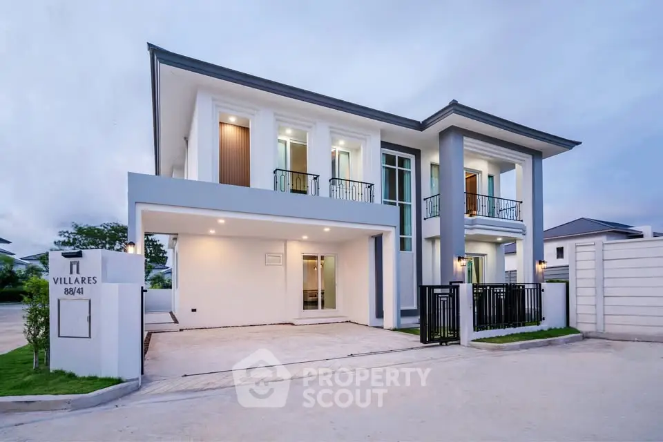 Modern two-story house with sleek design and spacious driveway in a serene neighborhood.
