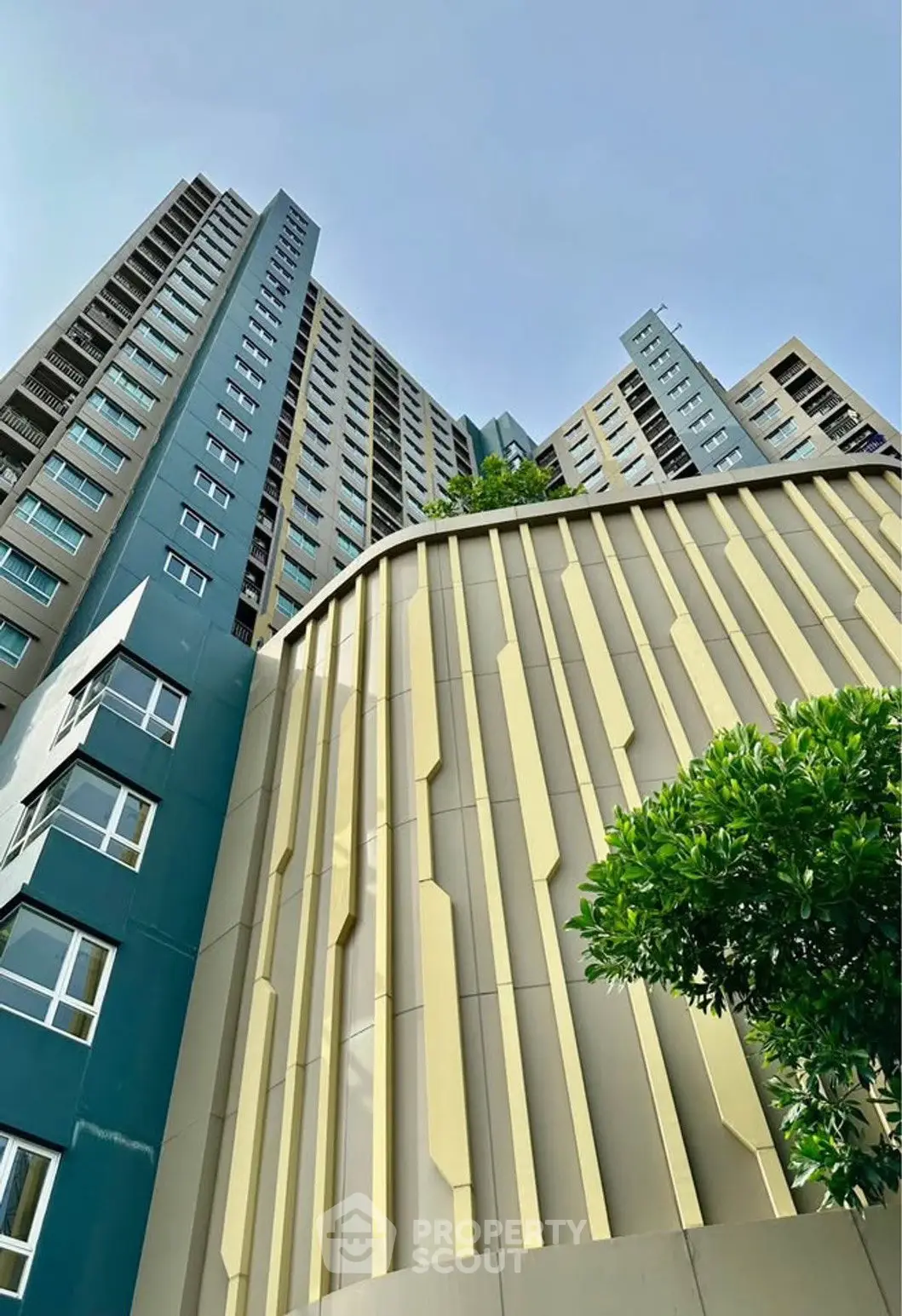 Modern high-rise building with unique architectural design and lush greenery.