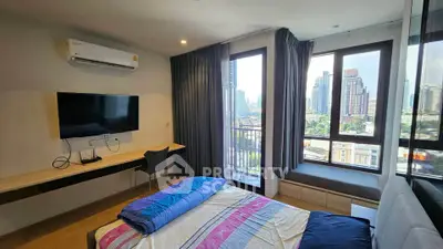 Modern bedroom with city view, featuring large windows, air conditioning, and a wall-mounted TV.