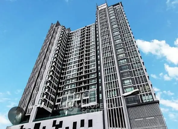Modern high-rise building with sleek architectural design against a clear blue sky.