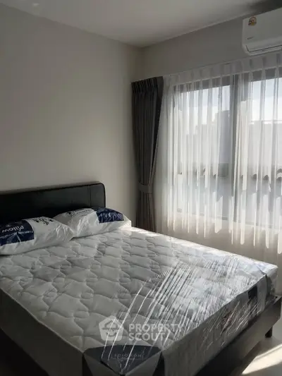 Bright bedroom with large window and modern furnishings in a stylish apartment.