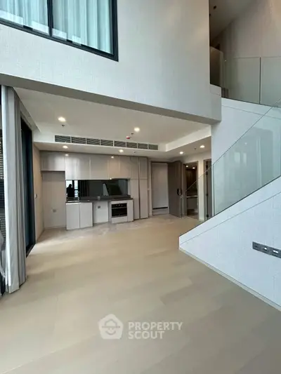 Spacious modern living area with high ceilings and sleek staircase