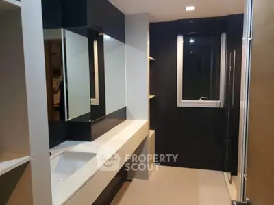Modern bathroom with sleek design and large mirror in contemporary apartment.