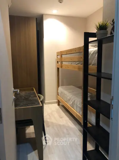 Cozy bedroom with bunk beds and study desk, ideal for compact living spaces.