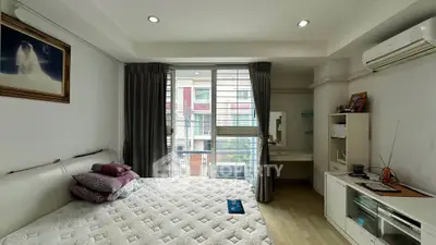 Modern bedroom with large window and air conditioning in urban apartment