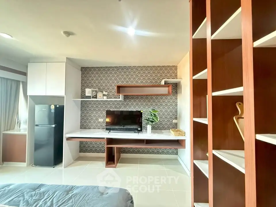 Modern living room with stylish shelving and sleek TV setup, perfect for contemporary urban living.