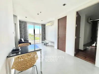 Modern living room with balcony view and stylish furniture in a bright apartment.