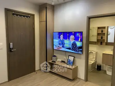 Modern apartment interior with TV and bathroom view, featuring sleek wooden finishes.