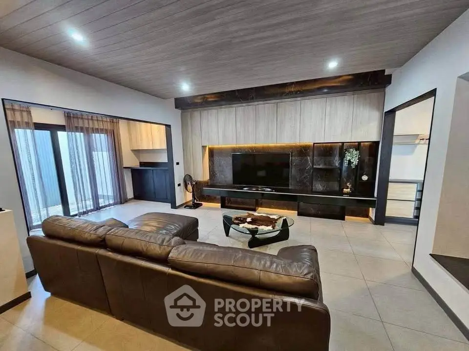 Spacious modern living room with sleek design and large leather sofa, perfect for relaxation and entertainment.