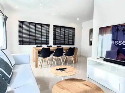 Modern living room with sleek furniture and dining area, featuring a stylish black and white color scheme.