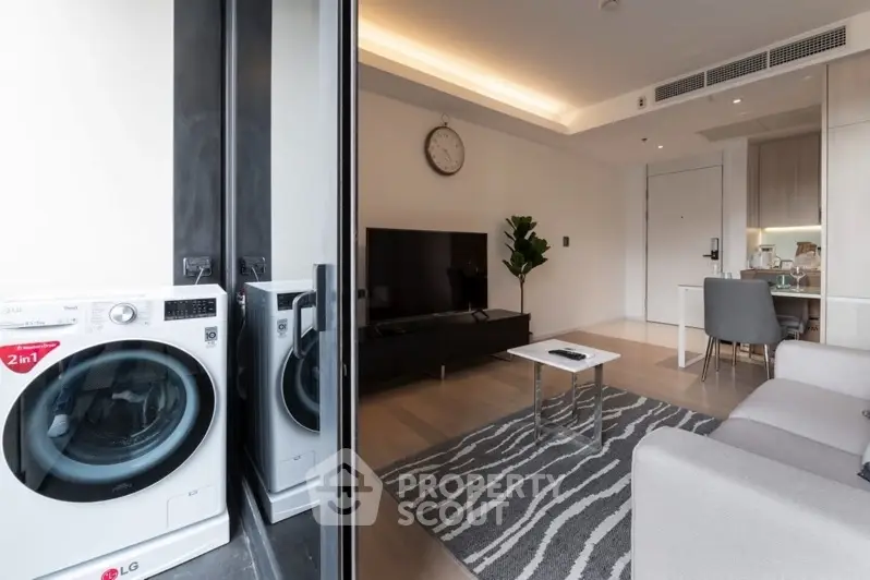 Modern living room with sleek design and in-unit washer, featuring open layout and stylish decor.