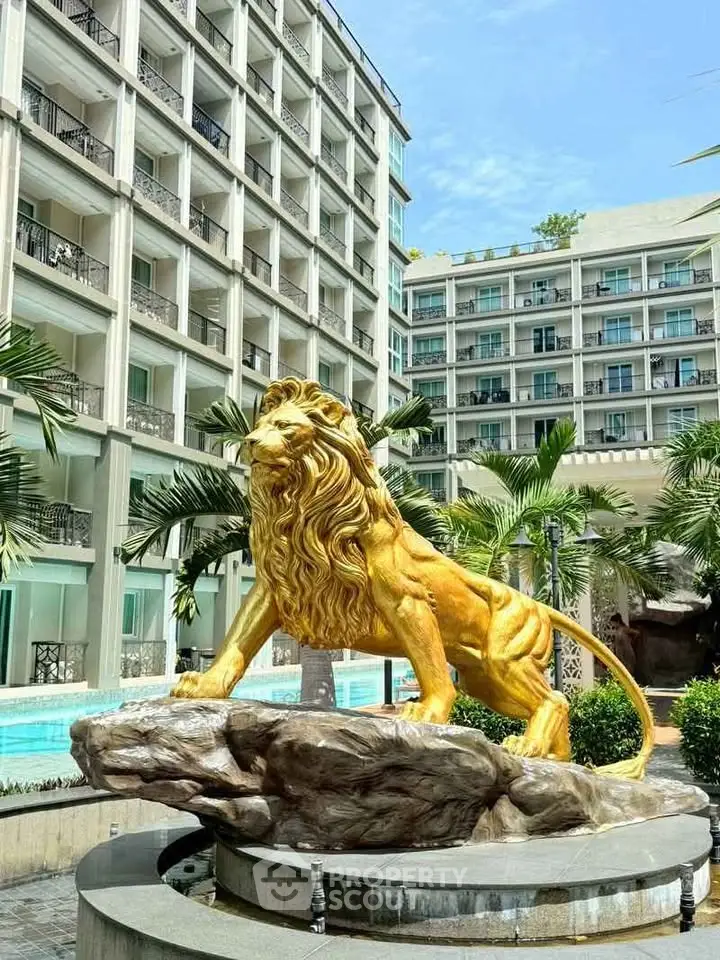 Luxurious apartment complex with stunning golden lion statue and lush greenery