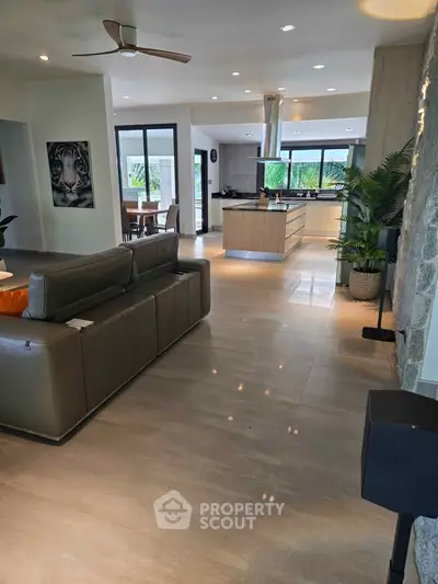 Spacious modern living room with open kitchen and stylish decor, perfect for entertaining.