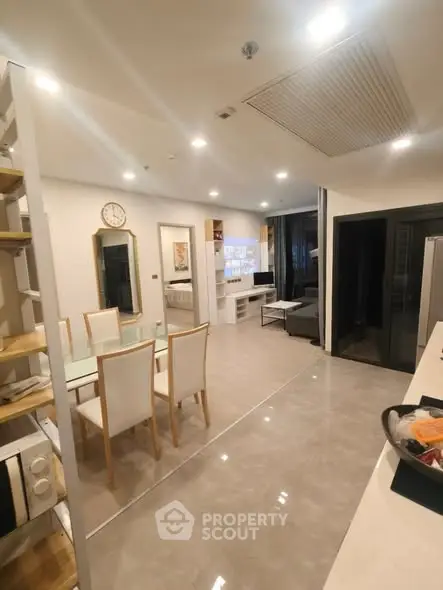 Modern open-plan living and dining area with sleek furnishings and neutral tones.