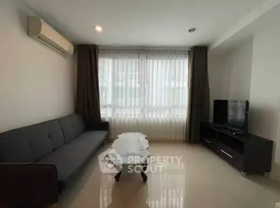 Spacious living room with modern sofa and large window in a bright apartment.