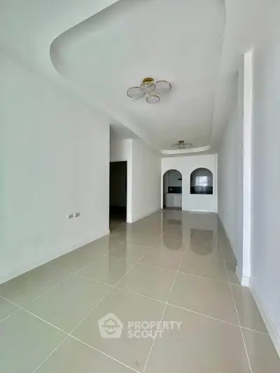 Spacious modern living room with elegant ceiling design and glossy tiled floor
