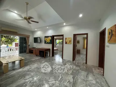 Spacious living room with marble flooring and modern decor in a stylish home.
