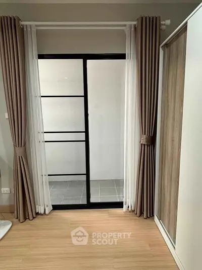 Modern interior with sliding glass door and elegant curtains in a cozy living space.
