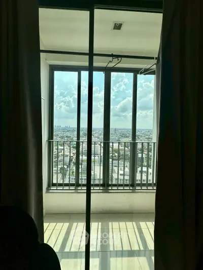 Stunning cityscape view from a modern apartment balcony with floor-to-ceiling windows.