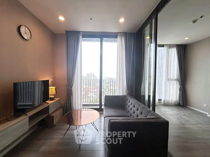 Modern living room with floor-to-ceiling windows and stylish furniture in a high-rise apartment.