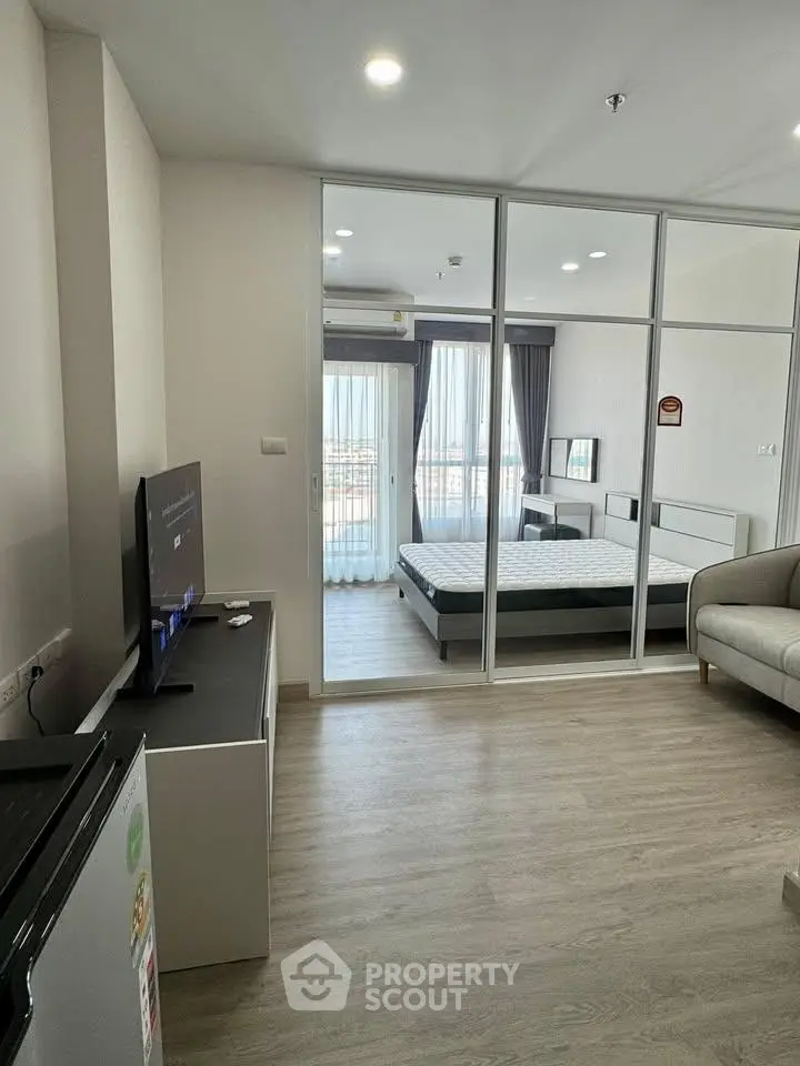 Modern studio apartment with glass partition, cozy living area, and natural light.