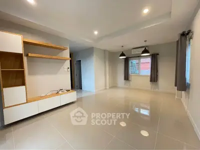 Spacious modern living room with sleek tile flooring and built-in shelving
