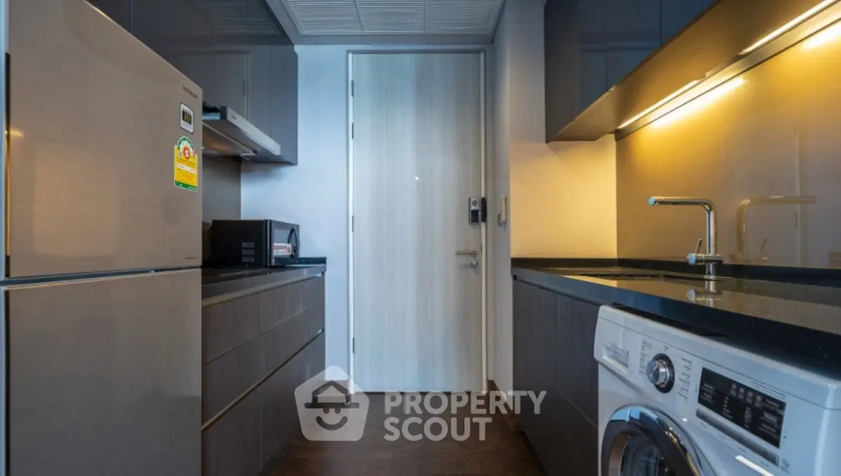 Modern kitchen with sleek appliances and washing machine in stylish apartment