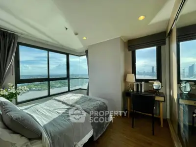 Luxurious bedroom with stunning city and river views, featuring large windows and elegant decor.