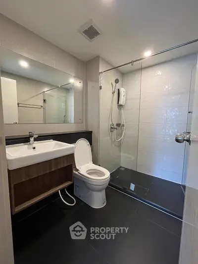 Modern bathroom with sleek shower and stylish vanity in contemporary apartment.