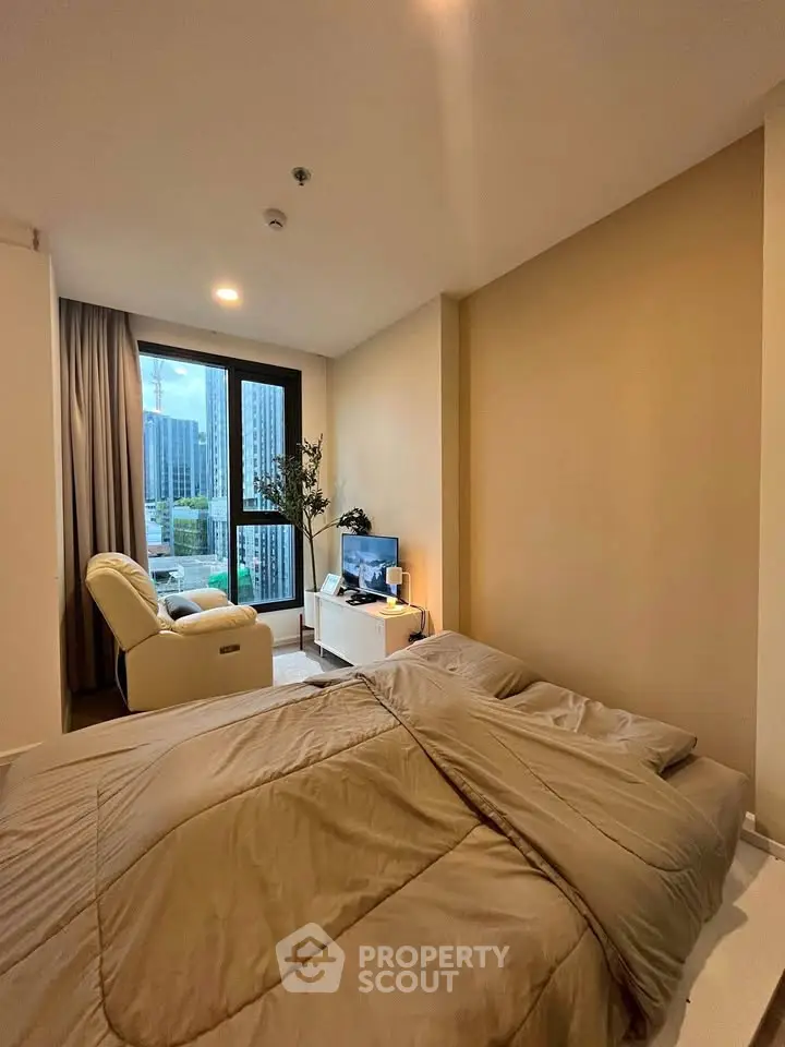 Cozy bedroom with city view, featuring a comfortable bed and modern decor.
