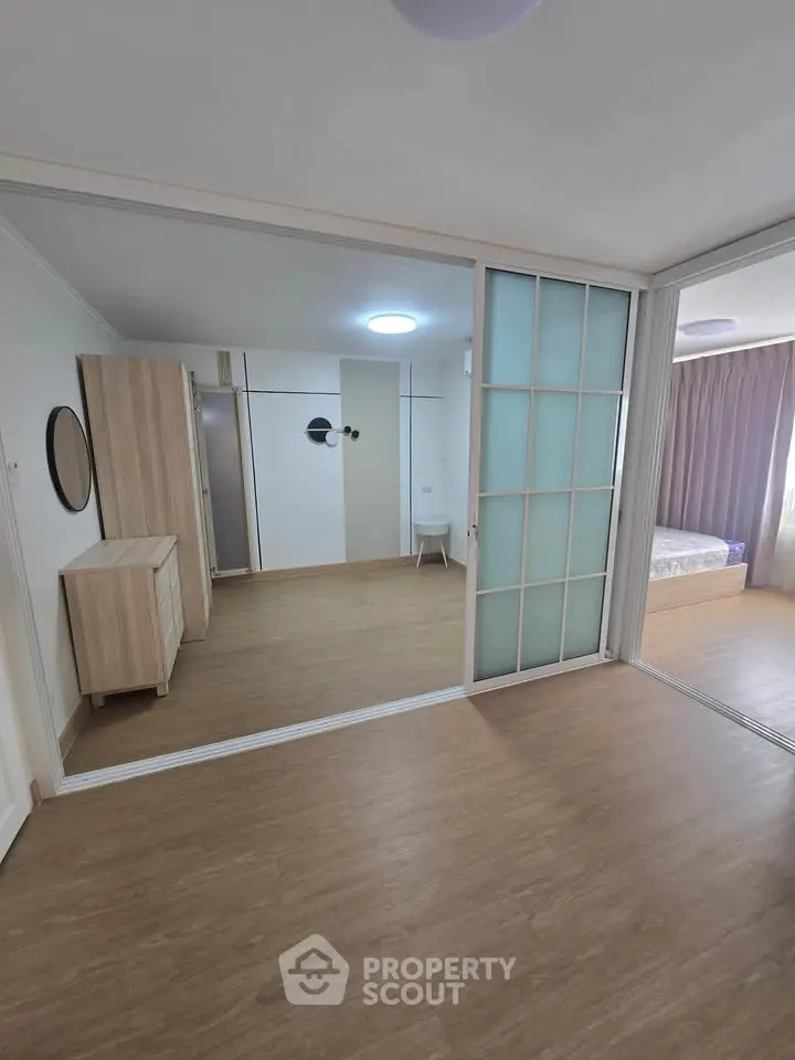 Spacious modern bedroom with sliding glass doors and wooden flooring