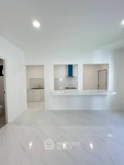 Modern minimalist kitchen with sleek white marble flooring and open layout design.