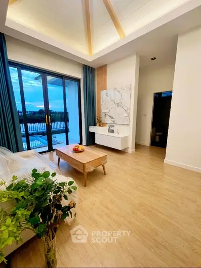 Elegant living room with high ceiling and balcony view, featuring modern decor and natural light.