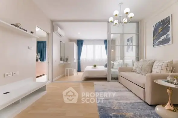 Modern living room with elegant decor and view into cozy bedroom
