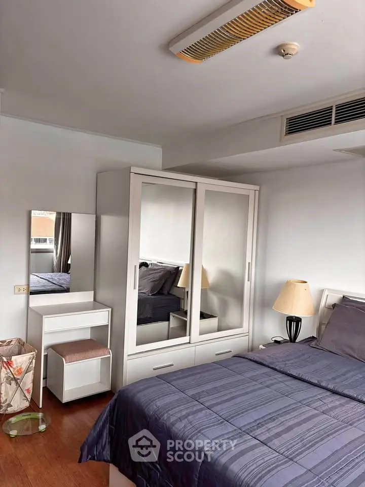 Cozy bedroom with modern furniture and ample storage in a stylish apartment.