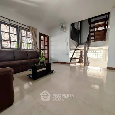 Spacious living room with modern staircase and natural light
