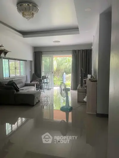 Spacious living room with modern decor and garden view, perfect for relaxation.