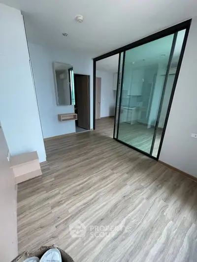 Spacious modern apartment with sleek wooden flooring and glass partition