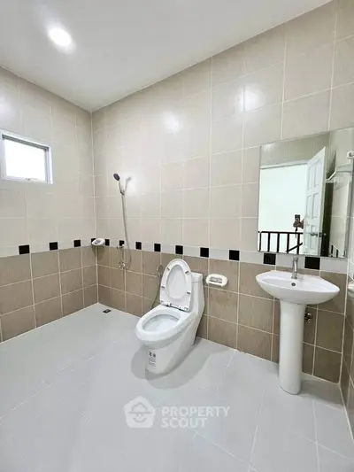 Spacious modern bathroom with sleek fixtures and neutral tiles