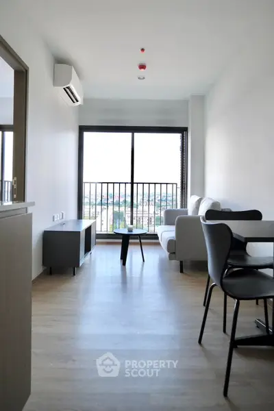 Modern living room with balcony view and sleek furniture in a bright apartment.