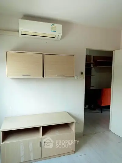 Compact living room with air conditioning and modern storage units.